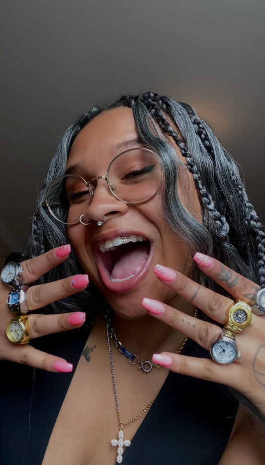 Hand wearing a stack of stainless steel watch rings with bold, industrial details. Handmade unisex jewelry by Sans Régence, featuring one-of-a-kind statement pieces inspired by functionality and rebellion.