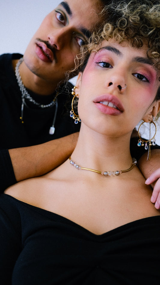 Close-up of a woman with jewelry and a man in the background