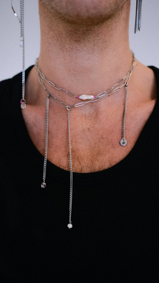 Necklace with small pendants on a person wearing a black shirt