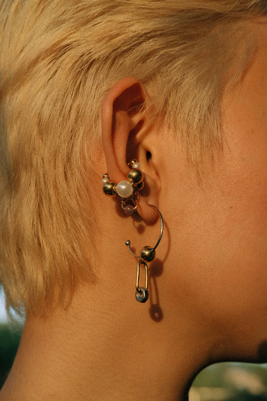 Close-up of an ear with multiple earrings on a blurred background