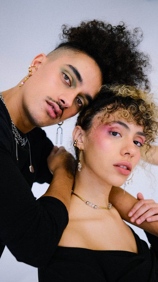 Two people posing closely together against a plain background