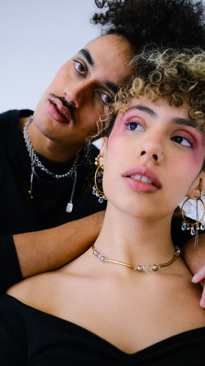 Two people posing closely together with a neutral background