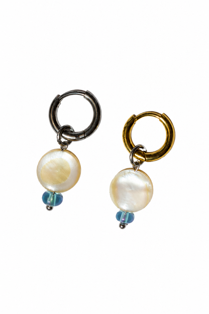 Boucles d’oreilles en acier inoxydable argent et or avec pendentifs en nacre naturelle et perles bleues, photographie produit sur fond blanc.