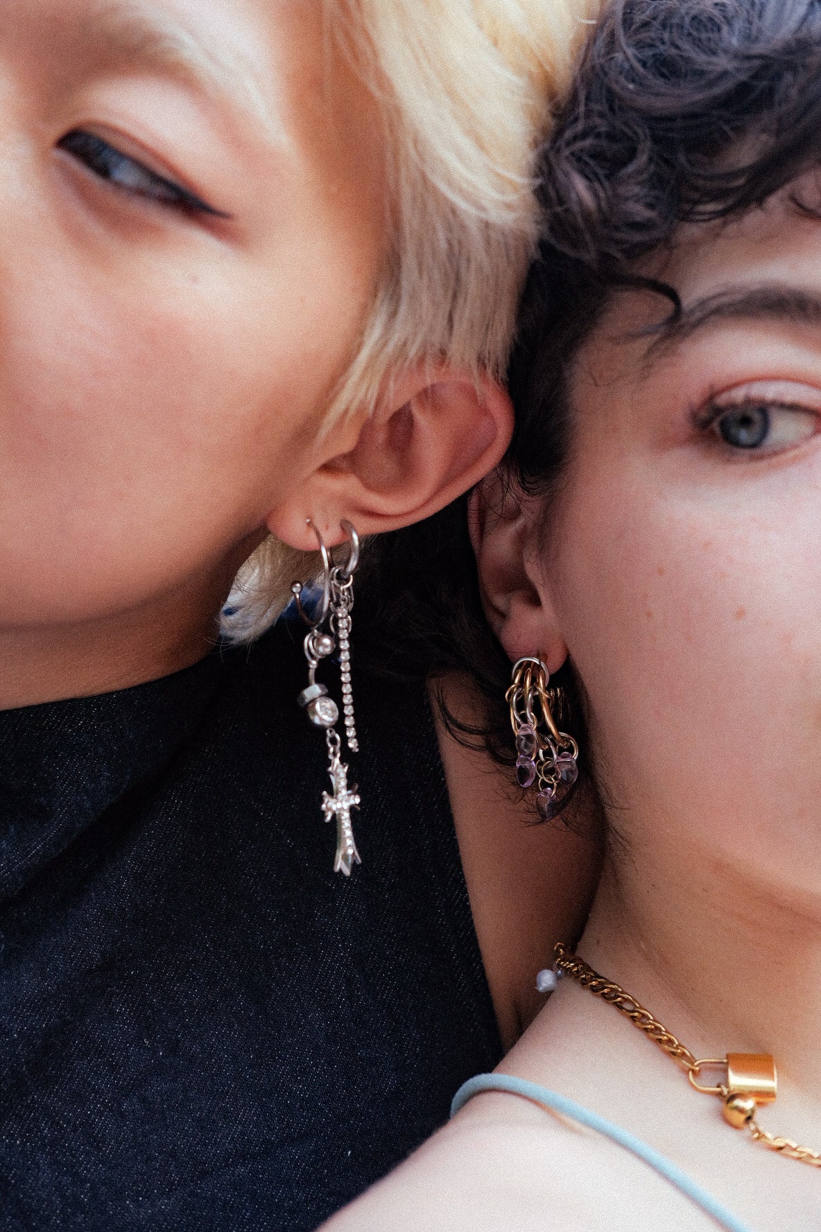 Close-up of two people wearing earrings and a necklace.