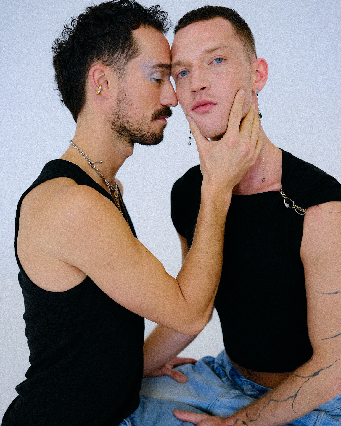 Two men embracing each other against a plain background