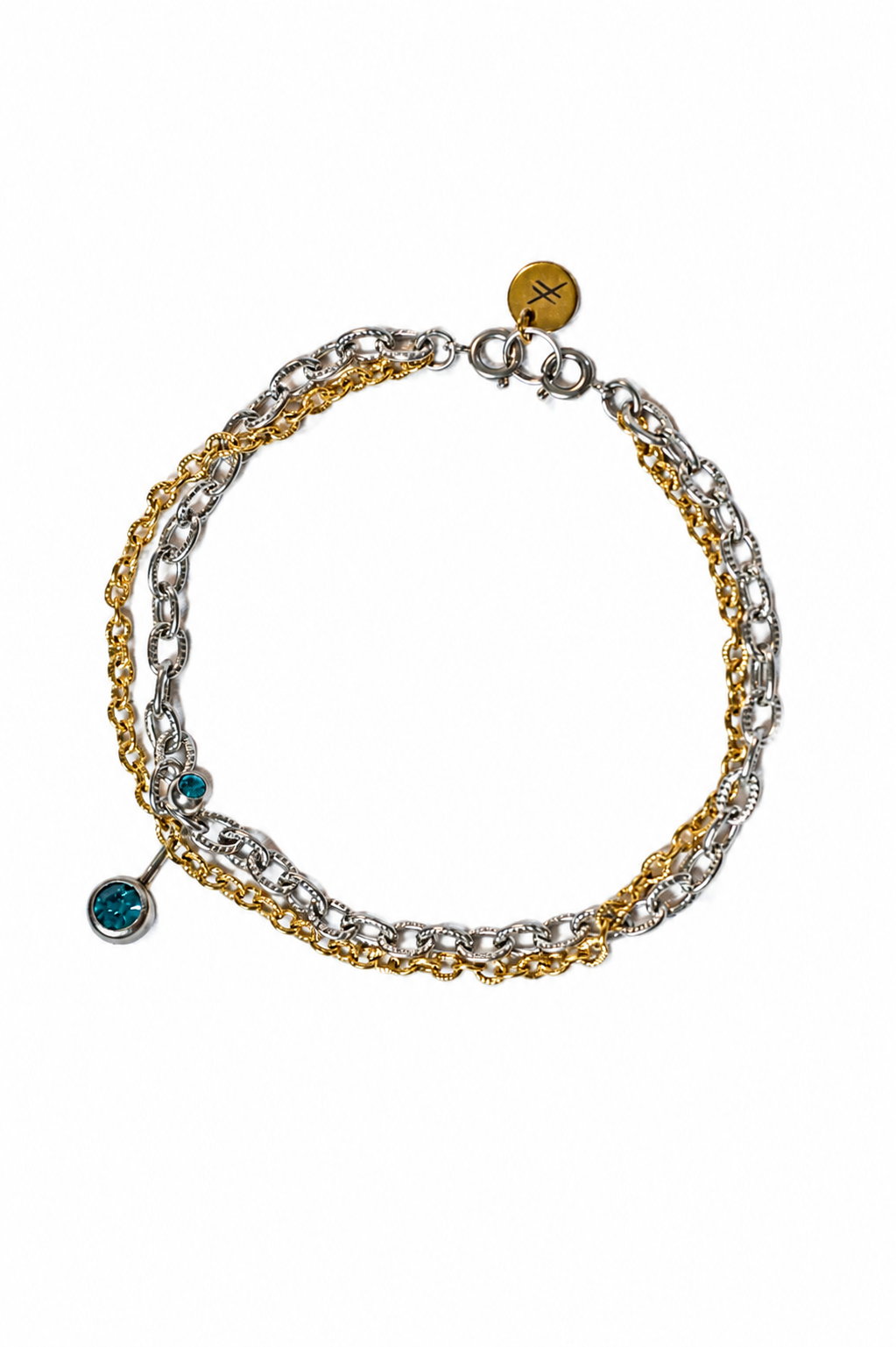 Bracelet en acier inoxydable argent et or avec un piercing de nombril avec cristaux bleus sertis, photographie produit vue du dessus sur fond blanc.