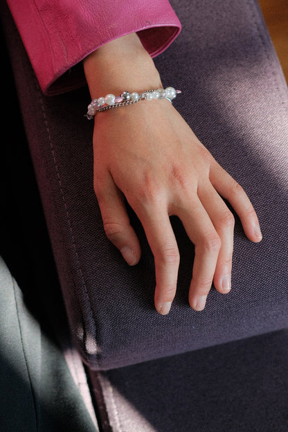 Hand wearing a bracelet on a dark surface