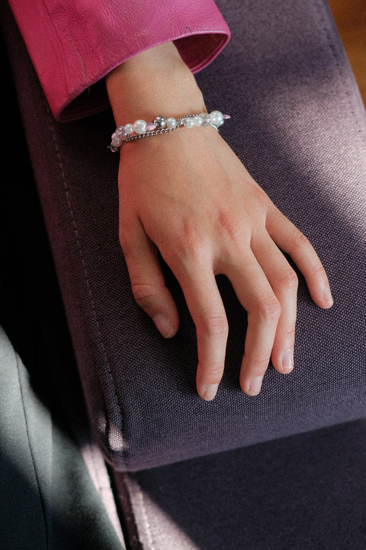 Hand wearing a bracelet on a dark surface