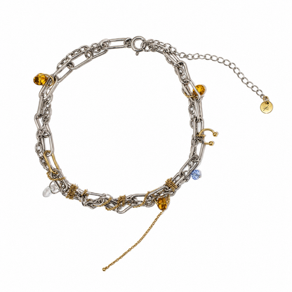 Collier choker en acier inoxydable argent et or avec breloques ambrées et chaîne pendante, photographie produit sur fond blanc.