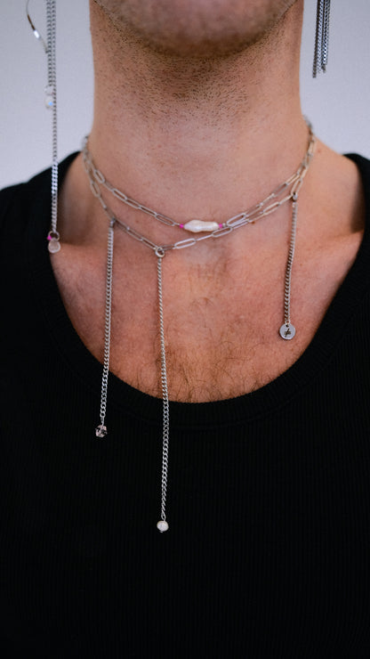 Necklace with small pendants on a person wearing a black shirt