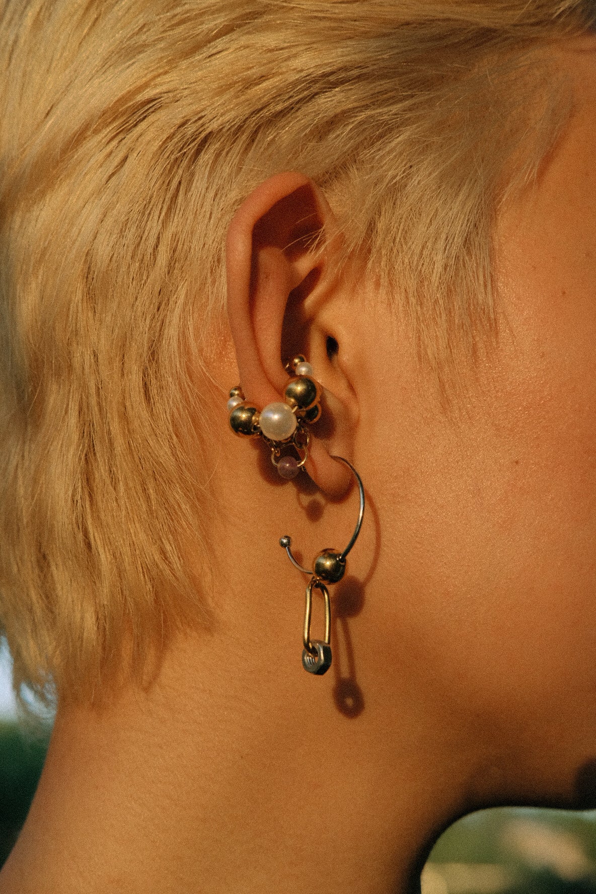 Close-up of an ear with multiple earrings on a blurred background