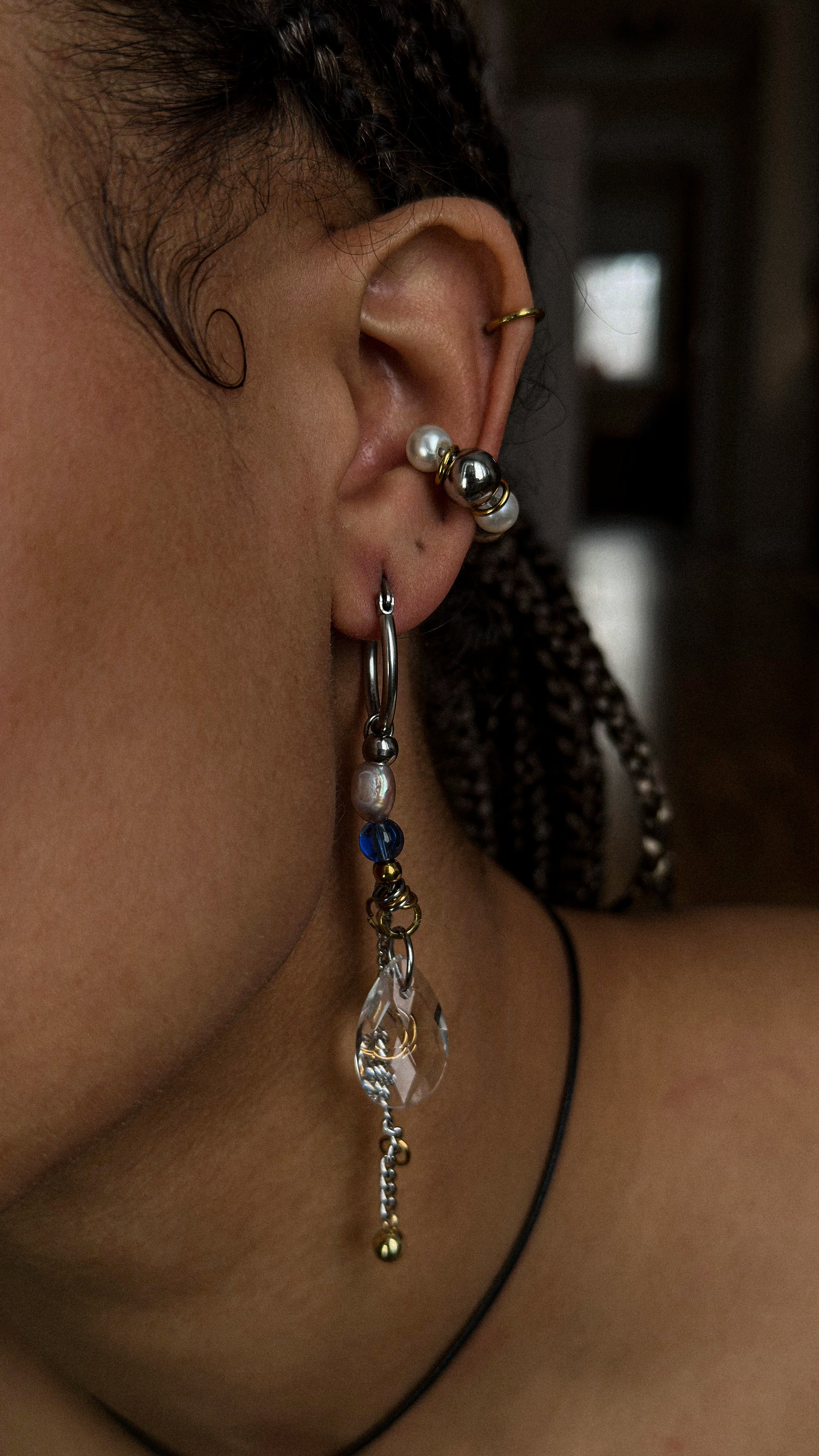 Close-up of an ear with multiple earrings and a blurred background