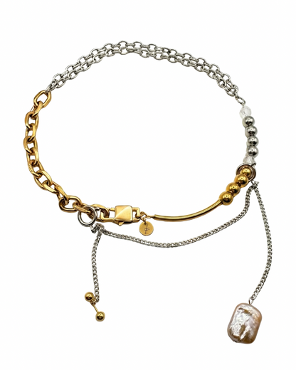 Multistrand bracelet with gold and silver chains and pearls on a white background